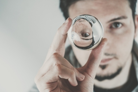 Portrait of a young man viewed through a crystal ball
