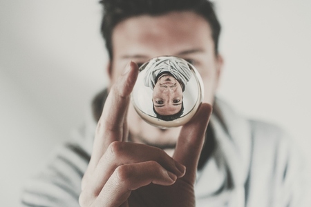 Portrait of a young man viewed through a crystal ball