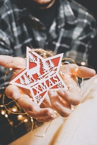 Hands holding a christmas star and fairy lights