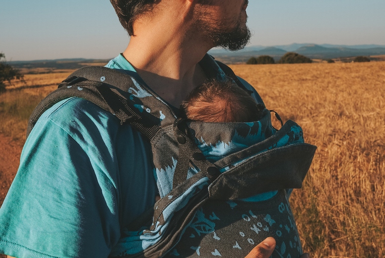 Single male parent carrying her baby with a backpack