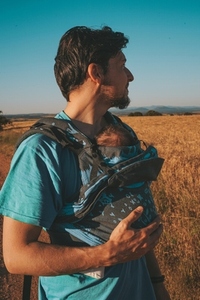 Single male parent carrying her baby with a backpack
