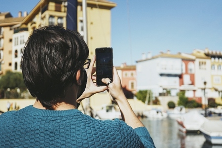 Young man taking photos with his mobile during his holidays in A