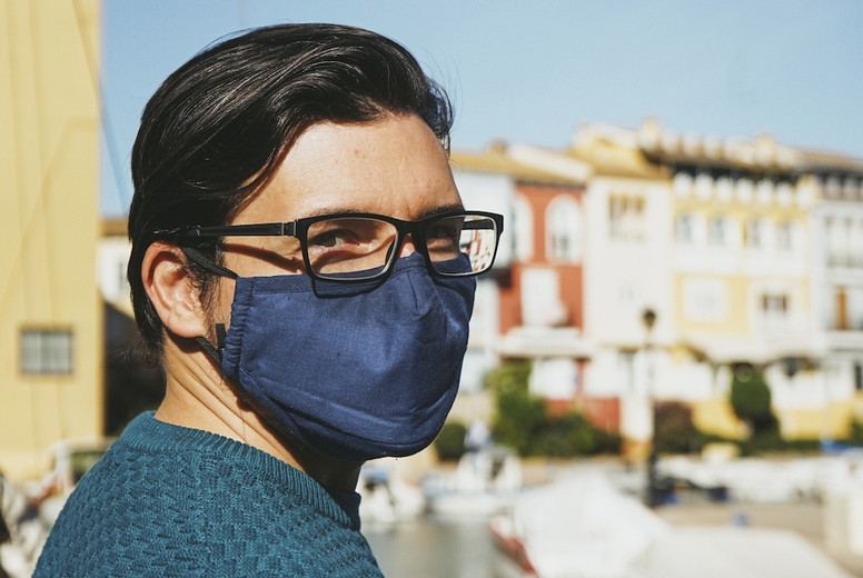 Young man wearing a face mask enjoying a sunny day in Alboraya,