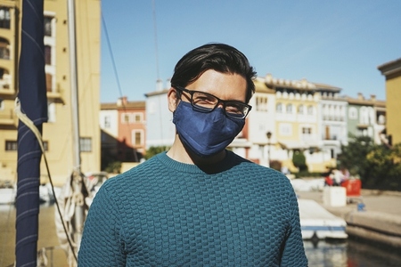 Young man wearing a face mask enjoying a sunny day in Alboraya
