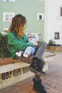 Young woman breastfeeding her baby outdoors in a sunny day