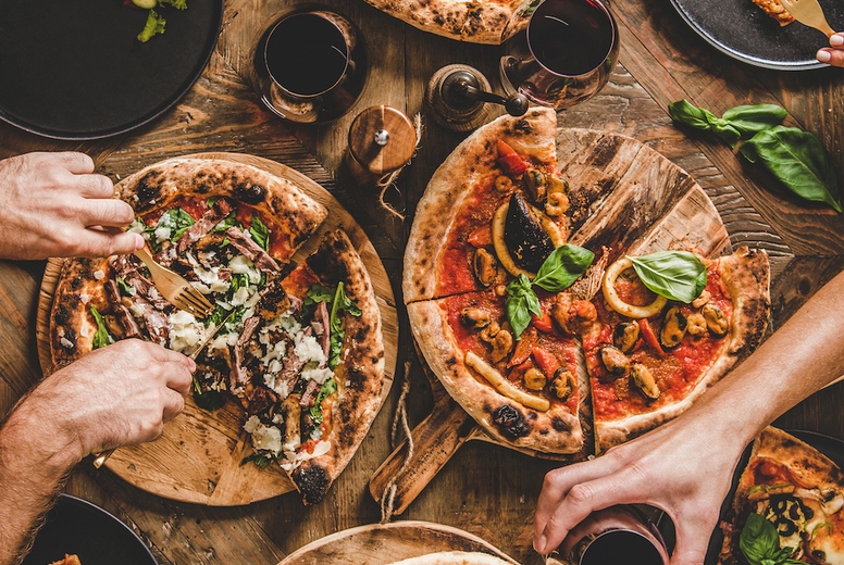 People having pizza dinner party with red wine, top view