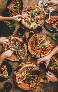 People having pizza dinner party with red wine  top view