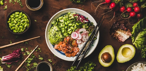 Salmon poke bowl with vegetables  greens  sushi rice  wide composition