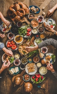 Flat lay of peoples hands holding traditional turkish breakfast cuisine food