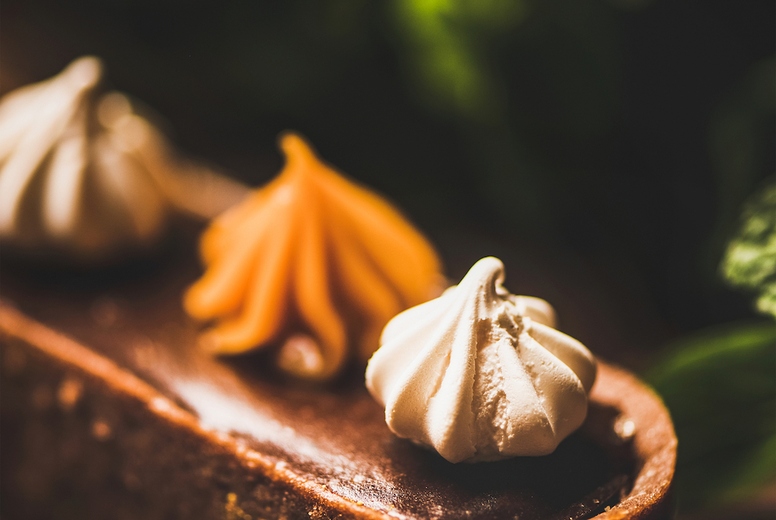 Belgian chocolate, Swiss merenge and caramel tart over rusty background