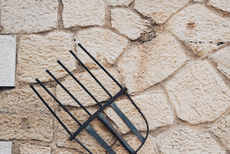Old pitchfork as decoration in a stone wall