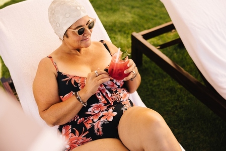 Mature woman relaxing and having a cocktail at a spa resort