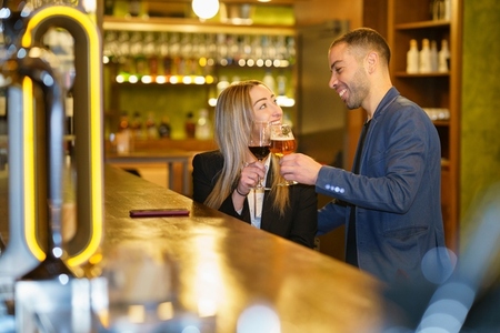 Multiethnic couple proposing toast in a pub