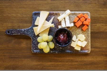 Cheese and grapes with sauce on charcuterie board