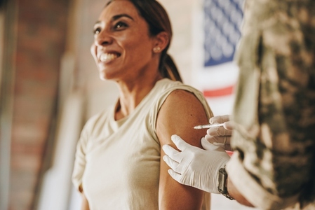 Female soldier receiving a vaccine in her arm