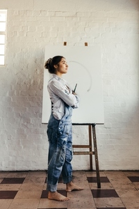 Female artist thinking of new creative ideas in her studio