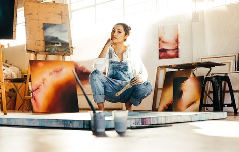 Young artist working on a new painting in her atelier