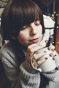 Young and dreamy woman enjoying a cup of coffee