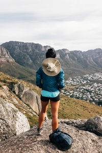 Rear view of young female standing on a mountain top and looking at view