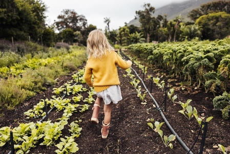 Young blonde girl walking through an organic farm