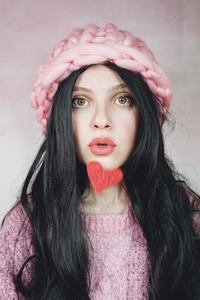 Romantic woman wearing pink clothes and holding a red heart