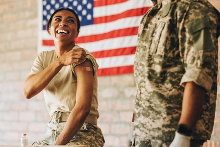 United States servicewoman smiling happily after getting vaccinated