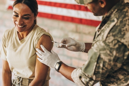 Happy female soldier getting vaccinated against covid 19