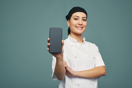Chef displaying a smartphone screen in a studio