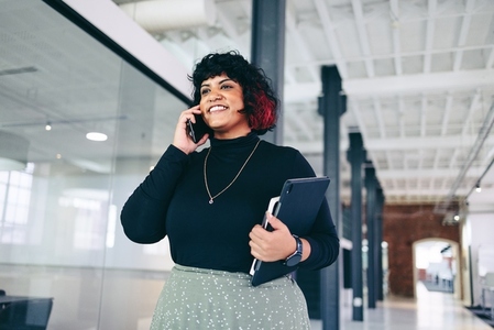 Happy businesswoman taking a phone call in an office