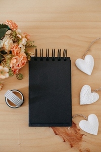 notebook with black sheets with copy space  bouquet of flowers and a white heart