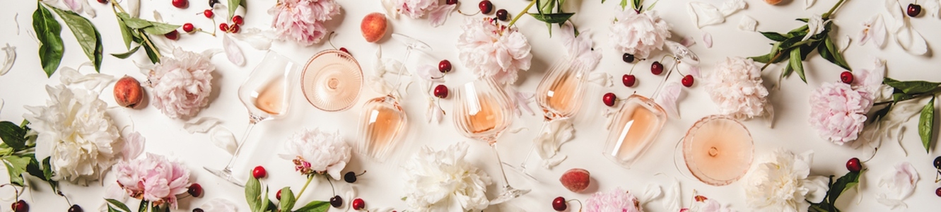 Rose wine in glasses with flowers and fruits  wide composition