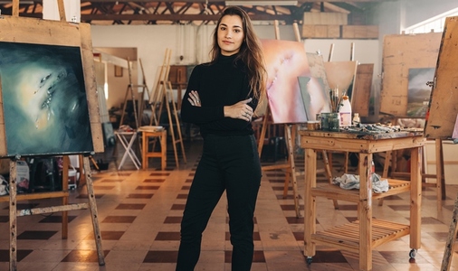 Professional painter standing in her atelier with her arms cross