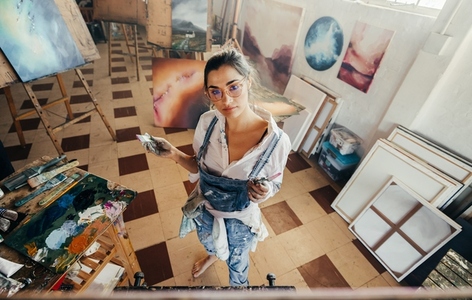 High angle view of a painter working in her studio