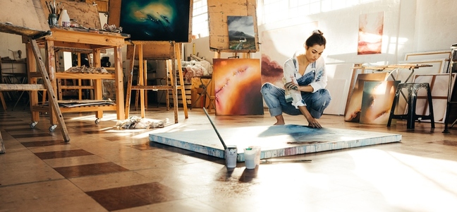 Artist working on a new painting in her studio