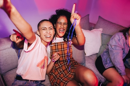 Two female friends taking a selfie at a house party