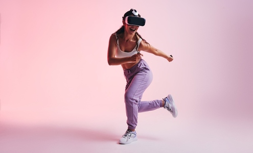 Happy young woman enjoying a virtual reality experience in a studio