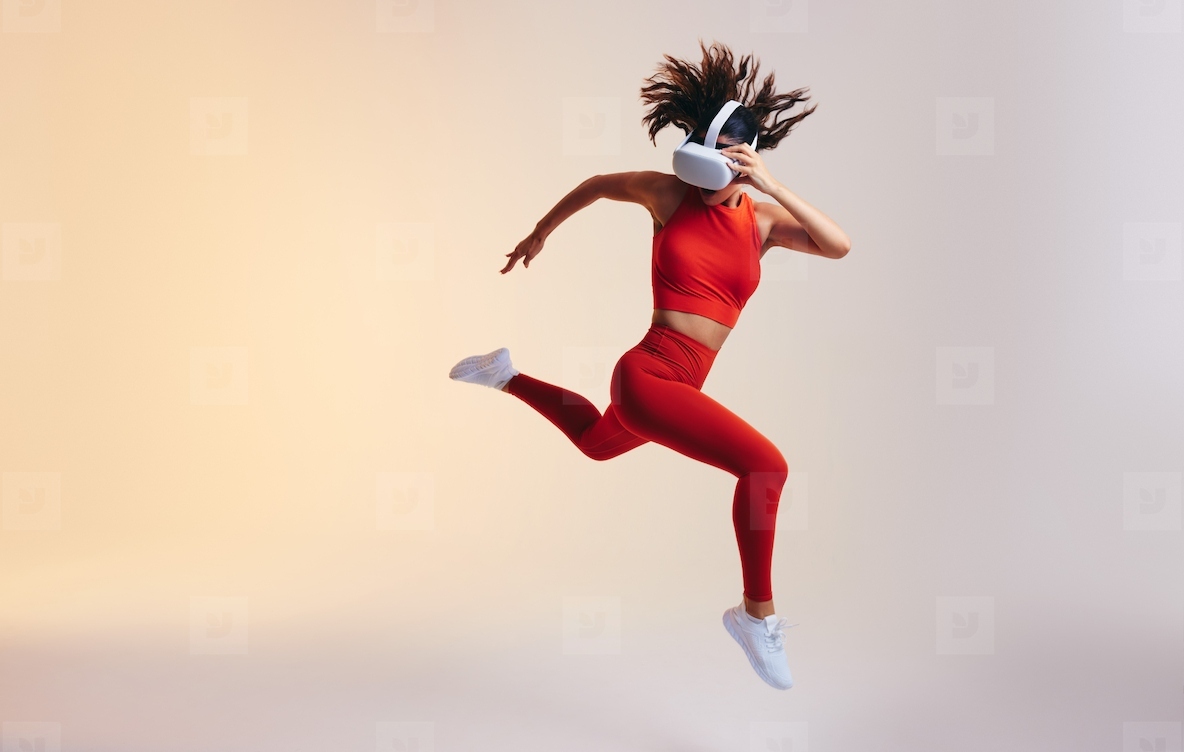 Sporty young woman sprinting while wearing a virtual reality headset