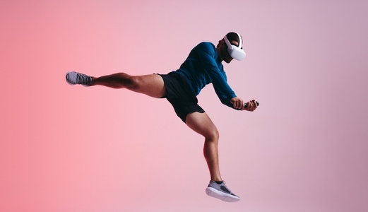 Sportsman jumping mid air while wearing a vr headest