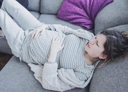 Young pregnant woman suffering pain at home
