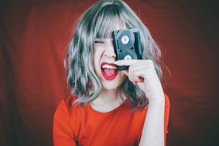 Artistic portrait with a model covering her face with a retro vi