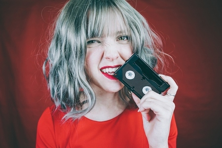 Artistic portrait with a model covering her face with a retro vi