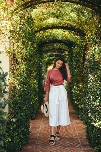 Beautiful young tourist woman walking through a plant tunnel