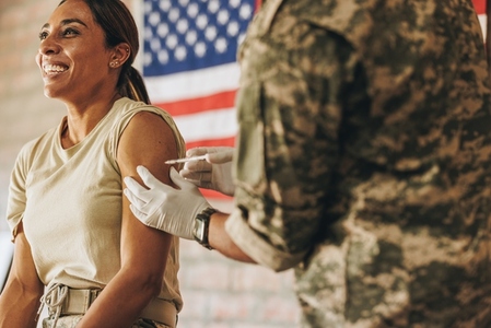 Ethnic female soldier getting inoculated in the military hospital