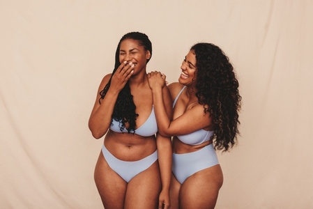 Cheerful young women laughing in blue underwear