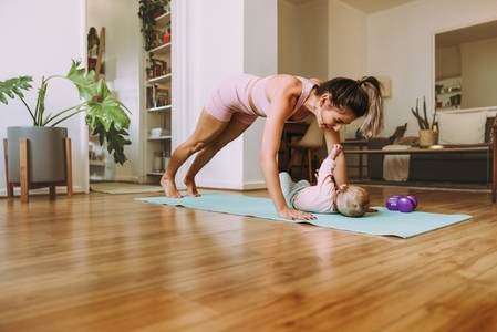 New mom working out with her baby on an exercise mat