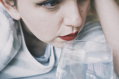 Portrait of a young woman hidden by a glass with a transparent d