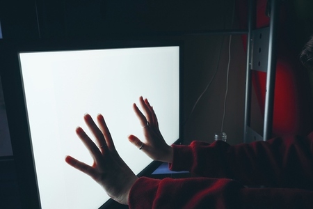 Hand touching a white screen