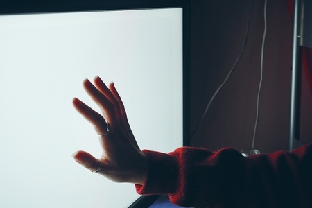 Hand touching a white screen
