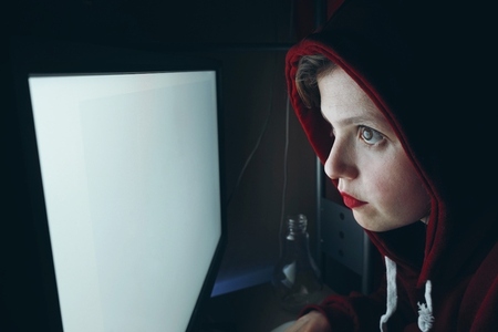 Young hacker woman in front of a white pc screen