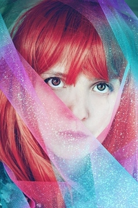 Artistic portrait of a young redhead woman covering by a glitter
